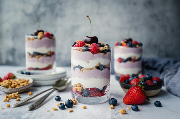 Close up of mixed berry yogurt parfaits on grey background.