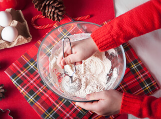 Child kid making dough for Christmas cookies, kitchen utensil and ingredient on the wooden...