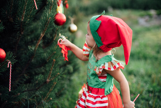 Christmas in july. Child waiting for Christmas in wood in july. portrait of little girl decorating christmas tree. winter holidays and people concept. Merry Christmas and Happy Holidays.