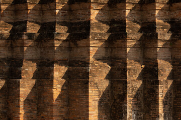 Ancient brick and shadows texture background of the Wat Mahathat temple foundations, Sukothai, Thailand