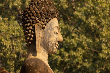 Close-up of the profile face of a Buddha statue in a temple in Sukhothai Historical Park, Thailand