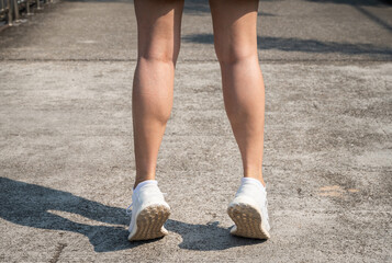 Cropped shot of female runner standing on her tiptoes for strengthen her calves.