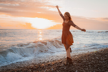 Fototapeta na wymiar woman dances on the seashore at sunset. Psychology of soul and body dance grace