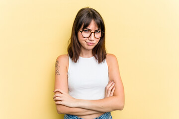 Young caucasian woman isolated on yellow background unhappy looking in camera with sarcastic...