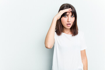 Young caucasian woman isolated on white background shouts loud, keeps eyes opened and hands tense.