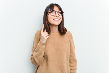 Young caucasian woman isolated on white background indicates with both fore fingers up showing a...