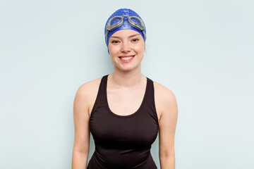 Young caucasian swimmer woman isolated on blue background happy, smiling and cheerful.