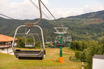 Mountain yellow lift on a summer day over the mountains. Old ski lift in the mountains in the sun. Carpathians, Ukraine.