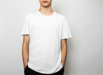 Blank white tshirt on young man studio shot on gray background