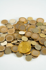 stack of coins and a bitcoin at top 