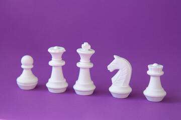 Teamwork concept. White chess pieces on a purple Teamwork concept. White chess pieces on a purple...