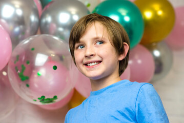 Fototapeta na wymiar portrait of a happy smiling boy on a holiday in front of the balls