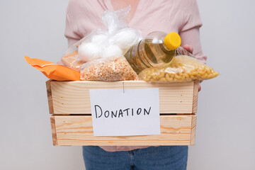 A woman holding a donation box with food for helping roop people in case of war and need
