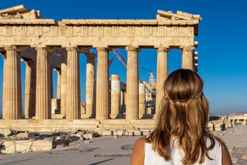 Rear view of tourist woman in white dress looking at Parthenon of Acropolis of Athens, Attica,...