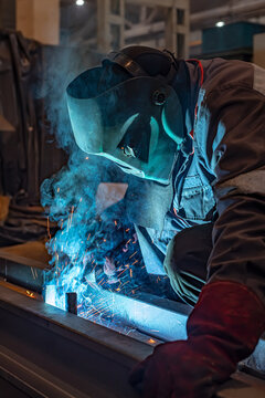 A metal welding worker is engaged in welding in a workshop.