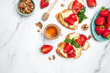 Two toasts or bruschetta with trawberries, cheese camembert nuts and honey. Summer breakfast. Healthy, clean eating. Vegan or gluten free diet