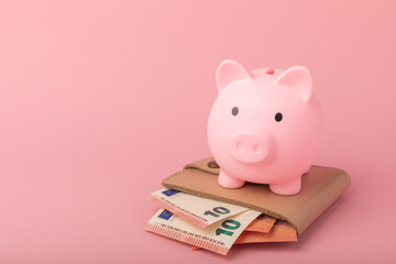 Piggy bank on a pink background. Piggy bank with a wallet and euro banknotes.The concept of investment and saving money.Investments.Place for milking text. Place to copy. mockup - obrazy, fototapety, plakaty