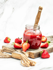 Strawberry jam in the glass jar, Homemade strawberry marmelade and fruits on a light background, vertical image. top view. place for text