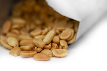 Closeup of open packet of peanuts showing peanuts inside.  Isolated against white background