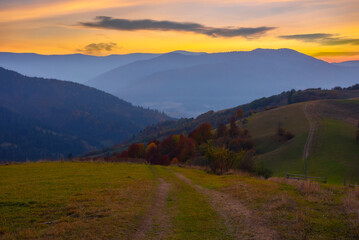 mountainous countryside at dusk. green grassy rolling hills on an autumn evening. carpathian rural...