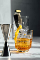 photography of whiskey cocktail glass with lemon peel as garnish with shadow