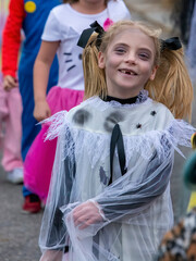 Little blonde girl in ghoul costume at a halloween parade