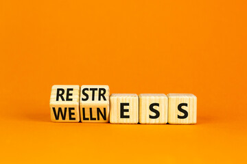 Restress for wellness symbol. Concept words Restress and Wellness on wooden cubes. Beautiful orange table orange background. Business Restress for wellness concept. Copy space.