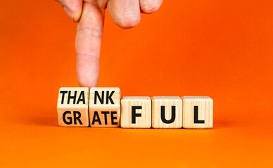 Thankful and grateful symbol. Concept words Thankful and Grateful on wooden cubes. Businessman...