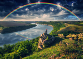 rainbow over the river. woman on a cliff above the canyon. nature of Ukraine
