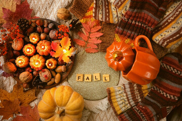 Fototapeta decorative candles, acorns, nuts, cup, pumpkin, dry leaves, knit sweaters. autumn seasonal composition. symbol of harvest, Mabon, thanksgiving, Halloween. fall time concept. flat lay obraz