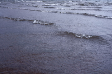 rainy weather - rain drops on water waves of river or lake