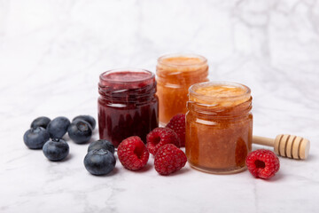 Jar of honey. Fruit honey with raspberries, blueberries, almonds and pistachios. Jams for health and beauty. Honey cream. Organic product of a vegetarian diet. Copy space.Copy space.
