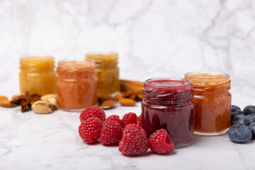 Jar of honey. Fruit honey with raspberries, blueberries, almonds and pistachios. Jams for health and beauty. Honey cream. Organic product of a vegetarian diet. Copy space.Copy space.