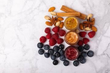 Jar of honey. Fruit honey with raspberries, blueberries, almonds and pistachios. Jams for health and beauty. Honey cream. Organic product of a vegetarian diet. Copy space.Copy space.