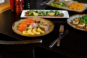 Seared ahi tuna sprinkled with sesame seeds and soy sauce with potatoes and lettuce, macro shot. 45 view