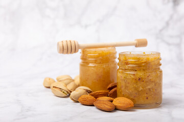 Nut honey jar on white wood. Cold medicine. Useful fortified product with almonds, pistachios, star anise and cinnamon for health and beauty. Vegetarian diet organic product. Copy space.place for text