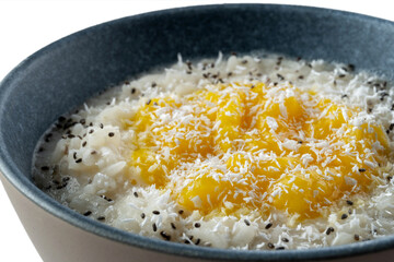 Milk rice porridge with orange jam. Sprinkled with coconut. selective focus.