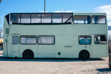 Mint-colored double-decker bus in a parking lot in summer. Old two-story bus no people or branding frontal from the side. Suitable as a mockup.