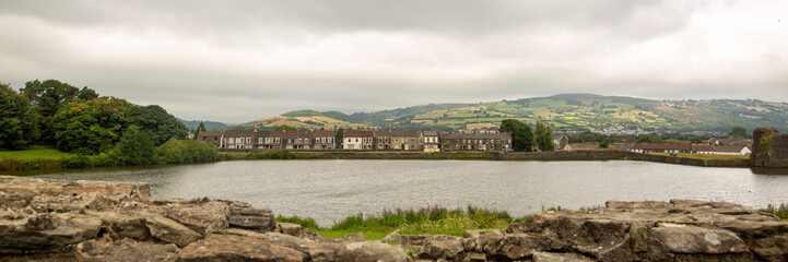 Fototapeta na wymiar Banner view of a small town across the river in cloudy weather
