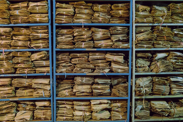 Shelves with old archival paper documents on racks in piles
