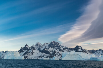 South Georgia Island. Landscape of Icebergs, mountain, curved clouds and ocean.