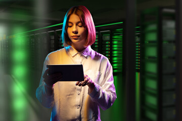 Hosting provider employee. Woman in data center. Girl with tablet computer. Woman indoors hosting...