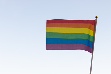 Rainbow flag, a symbol of the LGBT community, waving in the wind on a cloudy background Gay flag