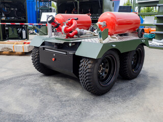 Modern fire fighting equipment. Barrel fire monitor. Unmanned equipment for flame extinguishing. Fire-fighting all-terrain vehicle with remote control. All-terrain vehicle with hose and red tanks