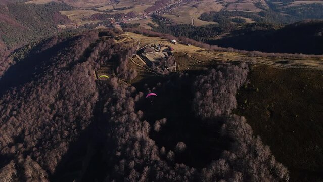 Two paragliders fly over the mountain Gemba in Ukrainian Carpathians region in early autumn