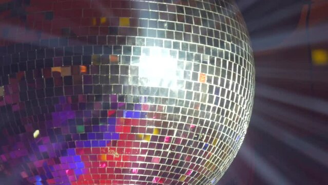Silver mirror disco ball at a party or celebration. Lighting design on the stage of the birthday party in the club. Abstract background of retro disco ball