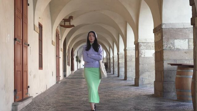Young woman in Prague walking and looking at the camera. Slow motion