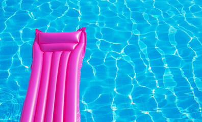 Pink inflatable mattress floating on water surface
