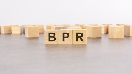 three wooden blocks with letters BPR - Business process reengineering - with focus to the single cube in the foreground
