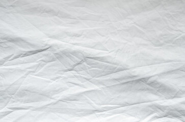 Top view of wrinkles on an unmade bed sheet after waking up in the morning.